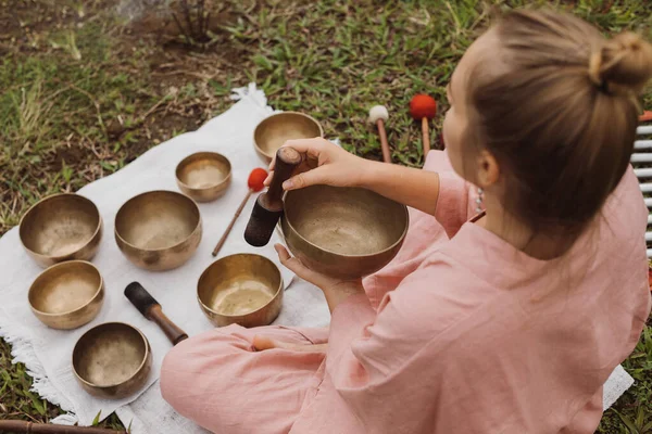 Young woman with white hair in a pink kimono plays on a singing bowl — Stock Photo, Image