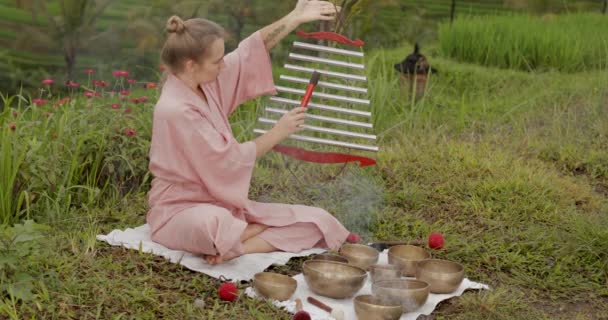 穿着粉色和服的金发女人，一边演奏喜马拉雅山的静坐音乐，一边弹奏 — 图库视频影像