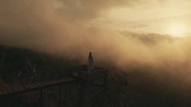 Дівчинка в довгому платті стоїть з плямистим вулканом Агунг. Захід сонця — стокове відео