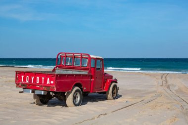 Umman 'daki Ras al Hadd plajındaki eski kırmızı Toyota kamyonet.