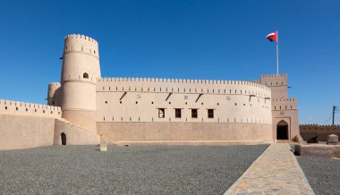 Exterior view of fort of Bani bu Hassan, Oman, with raised Omani flag clipart