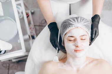 Spa 'daki müşterinin portresi. Gerçek doğal güzelliğe sahip bir kadın, doktoruyla düzenli estetik ameliyatta olan genç bir esmer.