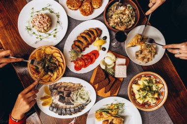 Ağız sulandıran Rus yemekleri olan büyük ahşap bir masa. Yemeklerin pişirildiği restoran en az evdeki kadar tatmin edici ve lezzetli.