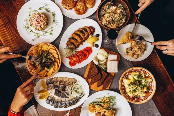 Ağız sulandıran Rus yemekleri olan büyük ahşap bir masa. Yemeklerin pişirildiği restoran en az evdeki kadar tatmin edici ve lezzetli.