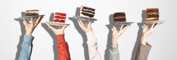 Concept for cafe or bakery with desserts: plates with different cakes in people\'s hands, place for your text