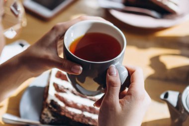 Sehpada serbest çalışan insanlar kahve içer, sohbet eder, bilgisayarda çalışır ve telefon kullanır.