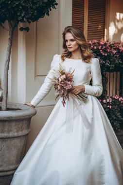 Georgia 'daki eski bir evin arka planında beyaz gelinlik giymiş güzel bir kızın zarif portresi.