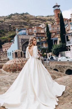 Gürcü kükürt banyosunun çatısında poz veren zarif gelinlikli güzel bir genç kız.