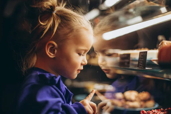 Mooi Meisje Bewonderenswaardig Onderzoekt Een Verlichte Vitrine Met Verschillende Heerlijke — Stockfoto