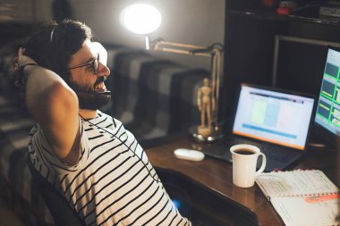 Tarz sahibi sakallı adam kendini izole ederek karantina sırasında geceleri evdeki bilgisayarda çalışıyor.