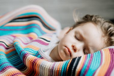 İki yıllık genç anne ve bebek birlikte uyur, sarılır, gündüz uykusunda çocuklar için konsept olur. Annem bebeğini uyuturken uyuyakalmış.