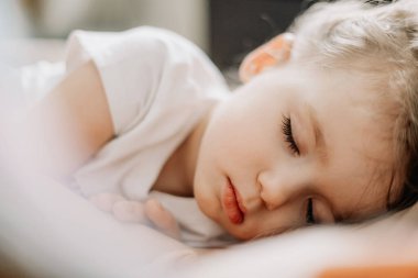 Beşiğinde uyuyan küçük sarışın bir kızın portresi. Çocuklar için sağlıklı gündüz uykusu kavramı
