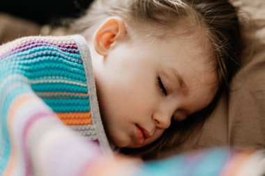 İki yıllık genç anne ve bebek birlikte uyur, sarılır, gündüz uykusunda çocuklar için konsept olur. Annem bebeğini uyuturken uyuyakalmış.