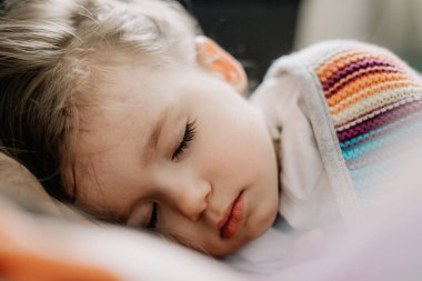 İki yıllık genç anne ve bebek birlikte uyur, sarılır, gündüz uykusunda çocuklar için konsept olur. Annem bebeğini uyuturken uyuyakalmış.