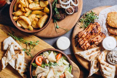 Büyük ve cömertçe nefis yemek masalarıyla kaplı ve üzerinde Ukrayna mutfağının çeşitli yemekleri var: barbekü, kızarmış patates, salata, sos, peynirli pita ekmeği.