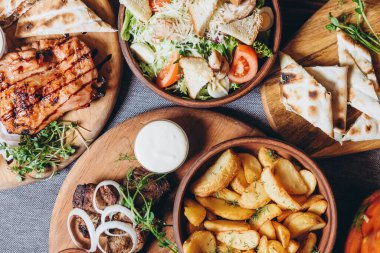 Büyük ve cömertçe nefis yemek masalarıyla kaplı ve üzerinde Ukrayna mutfağının çeşitli yemekleri var: barbekü, kızarmış patates, salata, sos, peynirli pita ekmeği.