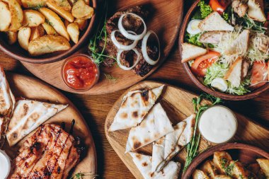 Büyük ve cömertçe nefis yemek masalarıyla kaplı ve üzerinde Ukrayna mutfağının çeşitli yemekleri var: barbekü, kızarmış patates, salata, sos, peynirli pita ekmeği.