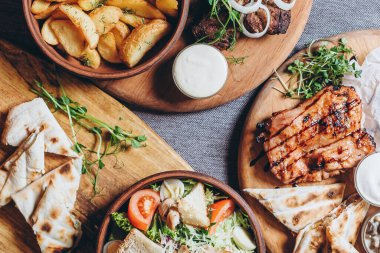 Büyük ve cömertçe nefis yemek masalarıyla kaplı ve üzerinde Ukrayna mutfağının çeşitli yemekleri var: barbekü, kızarmış patates, salata, sos, peynirli pita ekmeği.