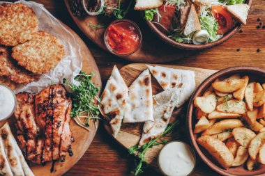 Büyük ve cömertçe nefis yemek masalarıyla kaplı ve üzerinde Ukrayna mutfağının çeşitli yemekleri var: barbekü, kızarmış patates, salata, sos, peynirli pita ekmeği.