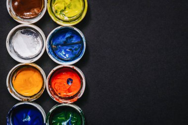 Arkasında boya kalıntıları olan boya kavanozlarının kapakları, sanatçı için arka plan.