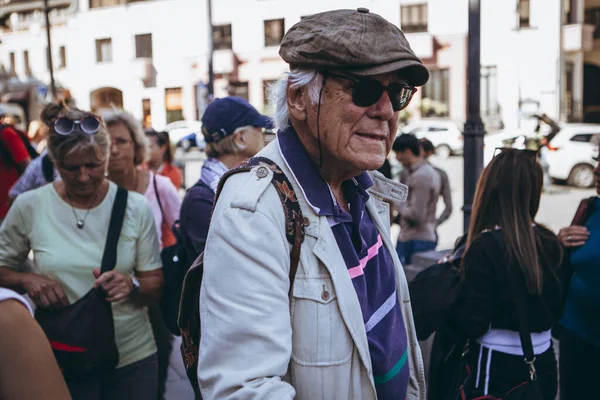 01.06.2019 Tiflis, Gürcistan: Gürcistan 'ın göbeğinde bir çubuğa yaslanmış yaşlı turist gezisini dinliyor
