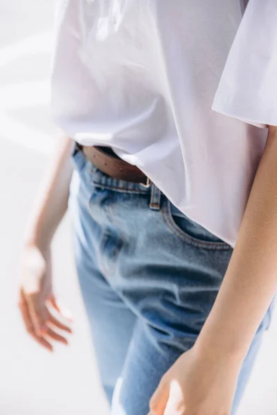 slender model dressed in summer clothes posing for promotional photo of women's clothing store on the city park background