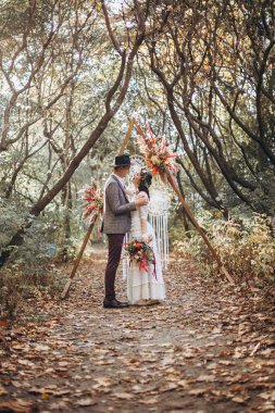 Gün batımında parkta düğün fotoğrafı çektiren zarif bir çift gelin.