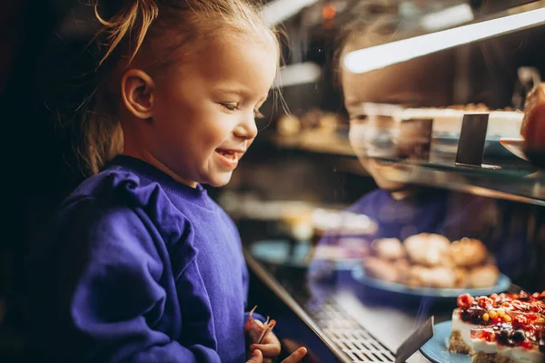 Mooi Meisje Bewonderenswaardig Onderzoekt Een Verlichte Vitrine Met Verschillende Heerlijke — Stockfoto