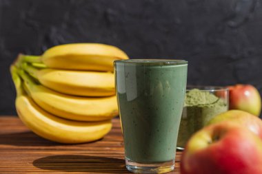 Bardakta pipetle kibrit tozu bulunan taze yeşil meyve püresi. Katı arkaplan, kopyalama alanı