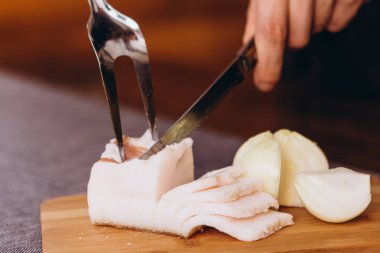 Bir parça Ukrayna domuz yağını dilimle ve ahşap bir tahtada servis et.