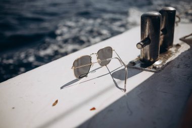 Küçük bir turist teknesinin kayığı açık mavi renkli deniz dalgalarının arka planına karşı doğrudan güneş ışığı altında