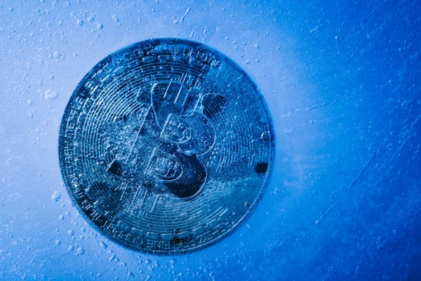 Donmuş ve buzla kaplanmış altın sembollü bitcoin. Kripto para birimi krizi ve bitcoin maliyetinin düşüşü kavramı 