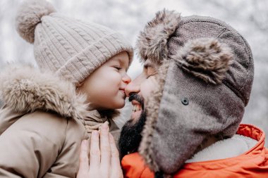 Mutlu aile portresi: baba ve küçük kızı parkta kış tatilinde. Mutlu, neşeli bir aile.