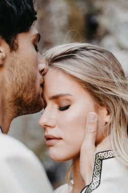 Gürültü etkisi, seçici odak: Düğün fotoğrafçılığı sırasında gelinlere sarılma ve öpücükler. Karı kocanın şık bir çifti.