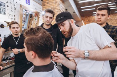 27.02.2020 Odessa, Ukrayna: Berberler profesyonel bir berberde öğrenir ve becerilerini geliştirirler. Hippi müşteri berber dükkanında haidresser ve kuaförü ziyaret ediyor.