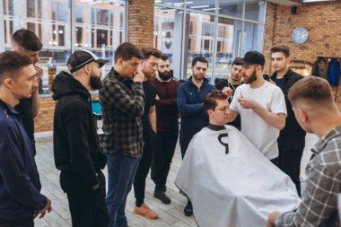 27.02.2020 Odessa, Ukrayna: Berberler profesyonel bir berberde öğrenir ve becerilerini geliştirirler. Hippi müşteri berber dükkanında haidresser ve kuaförü ziyaret ediyor.