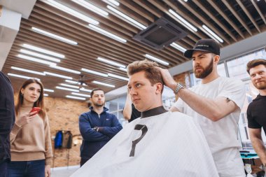 27.02.2020 Odessa, Ukrayna: Berberler profesyonel bir berberde öğrenir ve becerilerini geliştirirler. Hippi müşteri berber dükkanında haidresser ve kuaförü ziyaret ediyor.