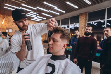 27.02.2020 Odessa, Ukrayna: Berberler profesyonel bir berberde öğrenir ve becerilerini geliştirirler. Hippi müşteri berber dükkanında haidresser ve kuaförü ziyaret ediyor.