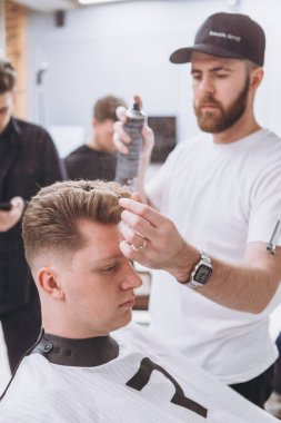 27.02.2020 Odessa, Ukrayna: Berberler profesyonel bir berberde öğrenir ve becerilerini geliştirirler. Hippi müşteri berber dükkanında haidresser ve kuaförü ziyaret ediyor.