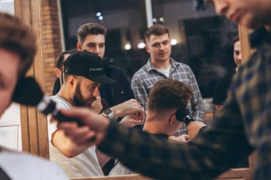 27.02.2020 Odessa, Ukrayna: Berberler profesyonel bir berberde öğrenir ve becerilerini geliştirirler. Hippi müşteri berber dükkanında haidresser ve kuaförü ziyaret ediyor.