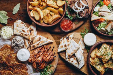 Büyük ve cömertçe nefis yemek masalarıyla kaplı ve üzerinde Ukrayna mutfağının çeşitli yemekleri var: barbekü, kızarmış patates, salata, sos, peynirli pita ekmeği.