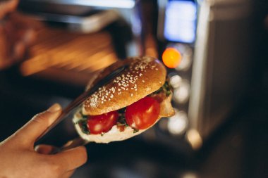 Bir fast-food kafede mikrodalga fırında sandviç yapmak ya da ızgara yapmak.