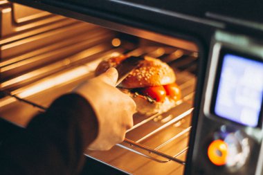 Bir fast-food kafede mikrodalga fırında sandviç yapmak ya da ızgara yapmak.