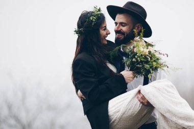 Muhteşem bir gelin ve şık bir damat, Boho düğün çifti, muhteşem manzaralı dağlarda lüks bir tören, mesaj için yer.