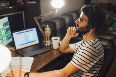 Tarz sahibi sakallı adam geceleri evden uzakta çalışıyor.