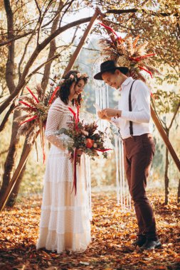 Gün batımında parkta düğün fotoğrafı çektiren zarif bir çift gelin.