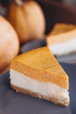 Bir parça balkabağı ev yapımı kek. Bayramlık tatlı konsepti. kabak turtası, rahat kafe arka planı, seçici odak, gürültü efekti