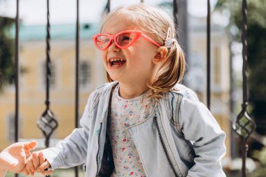 Samimi çocukların gülüşü ve eğlencesi, gülümseyen kız oynuyor ve fotoğraf için poz veriyor.