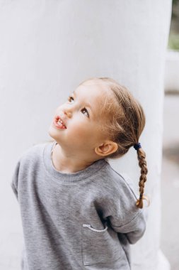 Samimi çocukların gülüşü ve eğlencesi, gülümseyen kız oynuyor ve fotoğraf için poz veriyor.