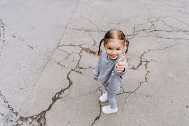 Samimi çocukların gülüşü ve eğlencesi, gülümseyen kız oynuyor ve fotoğraf için poz veriyor.